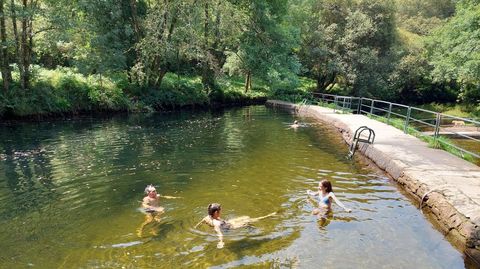 Una familia de turistas catalanes disfrutando de la playa fluvial de A Calzada