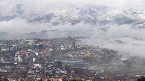 contaminacin, polucin .Vista general de Oviedo, cubierto de nubes y con las montaas nevadas al fondo 