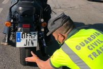 Un guardia civil examina el estado del neum�tico trasero de una moto.