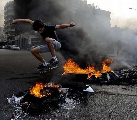 Un opositor antisirio salta con su monopat�n sobre una barricada de fuego en Beirut.