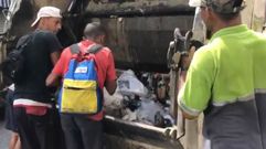 Gente buscando comida en la basura