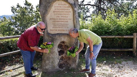 Paco y Eduardo Niebla dejan flores frente al monolito que recuerda a sus abuelos en A Guía, Ángela Iglesias y José Niebla.
