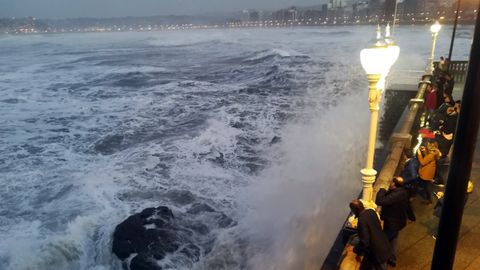 Los gijoneses sacan fotografías de los efectos del temporal Evi, en el Muro.Los gijoneses sacan fotografías de los efectos del temporal Evi, en el Muro