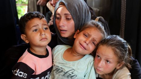 Una mujer y sus hijos, en el funeral de un grupo de palestinos muertos durante un ataque israel