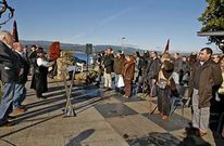 Os asistentes ao acto celebrado no paseo da Ribeira cantaron o himno co pu�o levantado.