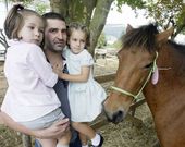 Un pap�, descubriendo a sus hijas los caballos de As San Lucas. 