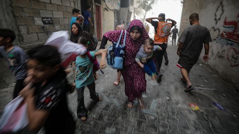 Palestinos huyen con sus hijos en brazos de los ataques israeles