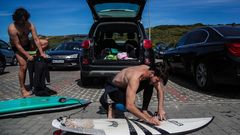 Surfistas preparan sus tablas en una playa de Ericeira, Portugal