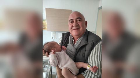 El alcalde de Abegondo, Jos� Antonio Santiso, con su nieta reci�n nacida en brazos