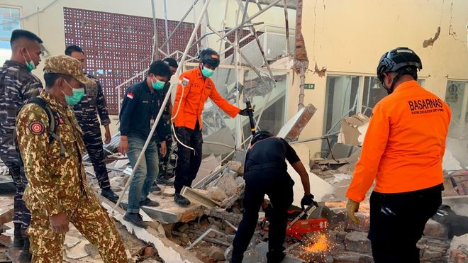 Equipos de rescate buscan posibles v�ctimas entre los escombros de un edificio en la isla indonesia de Flores.