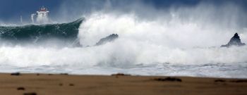 Al fondo, a la izquierda, un mercante guareci�ndose del temporal en San Rom�n (O Vicedo), donde el oleaje romp�a as� en la playa. 