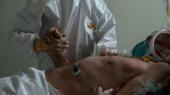 Sanitarios atienden a un paciente con coronavirus en la unidad de reanimaci�n (REA) del Complejo Universitario de Ourense, este mi�rcoles. Agotados pero al pie del ca��n un d�a tras otro. As� est�n en cr�ticos. No en vano, es la mejor definici�n del estado de �nimo de los profesionales sanitarios que lidian con los contagios de la covid-19, tanto desde Cuidados Intensivos (UCI) como en REA.
