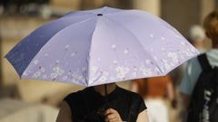 Una persona se protege del sol y el calor con un paraguas