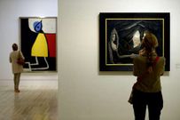 Una obra de Delvaux y otra de Miró, al fondo, en la muestra.