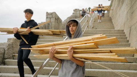 Chavales con tablas para las hogueras en Riazor