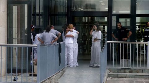 Dos trabajadoras de la residencia se abrazan emocionadas tras el realojo de los internos