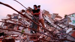 Personas entre los escombros de un edificio derrumbado en La Guaira (Venezuela).