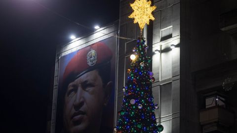 Un cartel del expresidente de Venezuela Hugo Chvez junto a un rbol de Navidad instalado este lunes en Caracas, despus de que el Gobierno anunciara el adelanto de estos festivos.