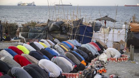 Inmigrantes rezando en la playa del Trampol�n de Ceuta, este mi�rcoles