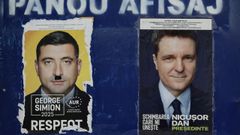 Carteles electorales de George Simion y Nicusor Dan en una calle de Bucarest