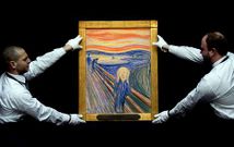 Dos empleados de Sotheby?s sostienen la obra de Munch antes de la subasta del cuadro.