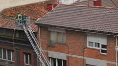 Bomberos inspeccionando un tejado tras la fuerte granizada en Gij�n