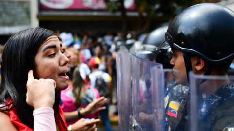 Una partidaria de Guaid� se enfrenta a un miembro de la Polic�a Bolivariana durante la manifestaci�n de ayer en Caracas