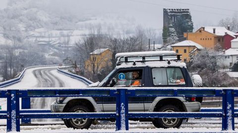 Un miembro del equipo de rescate pasa por una carretera a la altura de Aller, Asturias este s�bado donde miembros de la UME se han incorporado a la b�squeda del segundo operario desaparecido cuando trabajaba con una m�quina quitanieves al producirse un alud de nieve en el puerto de San Isidro.