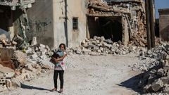 Una ni�a pasa por una zona de la ciudad de Tallmannis destruida por los bombardeos 