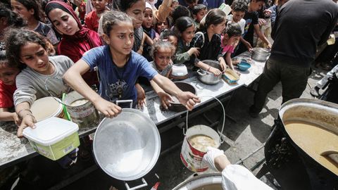 Un grupo de palestinos espera a conseguir comida