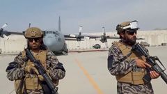 Miembros de la unidad militar montan guardia mientras el portavoz talib�n pronuncia su discurso en el aeropuerto de Kabul