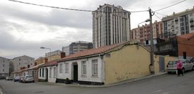 Las casitas de una sola planta del grupo Pardo de Santayana, con las torres de los Rosales al fondo. 