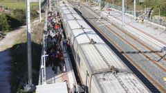 Decenas de pasajeros, saliendo de un tren en Sarria procedente de Madrid.
