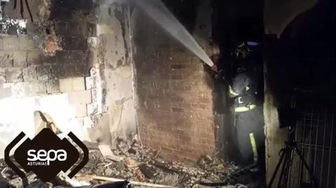 Un bombero, durante la extinci�n del incendio en Avil�s