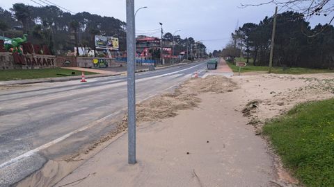 La arena tapa la acera en la PO-308 en Major tras la limpieza de la calzada