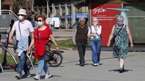Gijoneses protegidos con mascarillas pasean por el centro de la ciudad