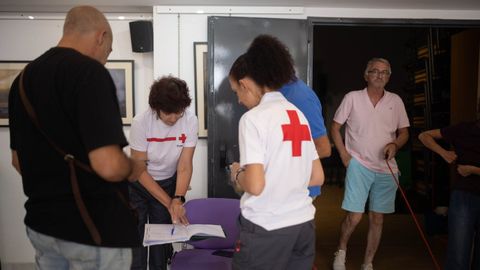 Miembros de la Cruz Roja atienden a vecinos desalojados por el incendio de Niebla