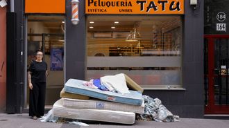Lorena Montero, propietaria de la peluquer�a Tat�, con el mont�n de colchones a las puertas de su negocio despu�s de que los okupas los lanzaran por la ventana