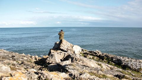 Un hombre fotograf�a el mar en La Isla, Asturias