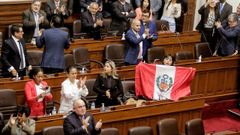 Una diputada despliega la bandera de Per durante la sesin en la que se aprob la mocin de destitucin de Pedro Castillo