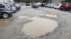 Grandes baches llenos de barro llenan las zonas de paso del aparcamiento de tierra del Snchez Aguilera.