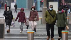 Una pareja atraviesa el paso de peatones en una calle de Beijing