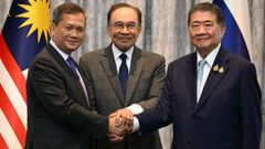 El primer ministro de Camboya, Hun Manet (izquierda), le da la mano a su homlogo tailands interino, Phumtham Wechayachai (derecha), en presencia del malayo Anwar Ibrahim (centro). 