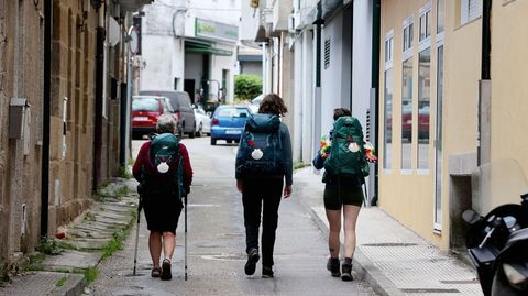 Tres peregrinas pasan por la calle A Santia, la nica zona del Camino de Santiago a su paso por la urbe que est pendiente de arreglar.