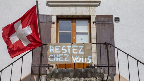 Un cartel en una vivienda de Bourdigny, cerca de Ginebra, anima a los vecinos a quedarse en casa