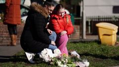 Una mujer y su hija depositan flores cerca del lugar donde fue hallado sin vida el beb� en Brighton.