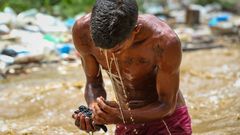 Un joven �minero� busca restos en el r�o Guaire