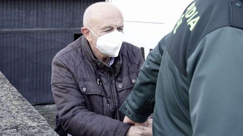 El presidente del Colegio de Enfermería de Pontevedra, custodiado por un guardia civil en el 2021.