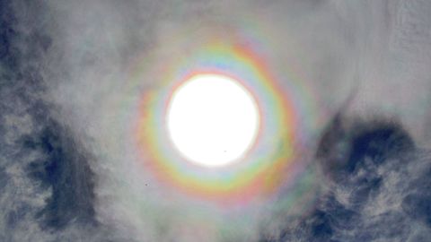 Corona Solar. Paseo del muro de San Lorenzo, Gij�n. Se trata de un fen�meno �ptico que aparece alrededor del Sol en forma de anillos de colores asemejandose a un arco iris. Las nubes que crean este fotometeoro son nubes formadas por gotas de agua (g�nero Altocumulus)