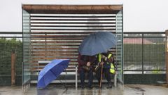 Dos mujeres, cubri�ndose de la lluvia en una marquesina en Teo, en una imagen del martes.